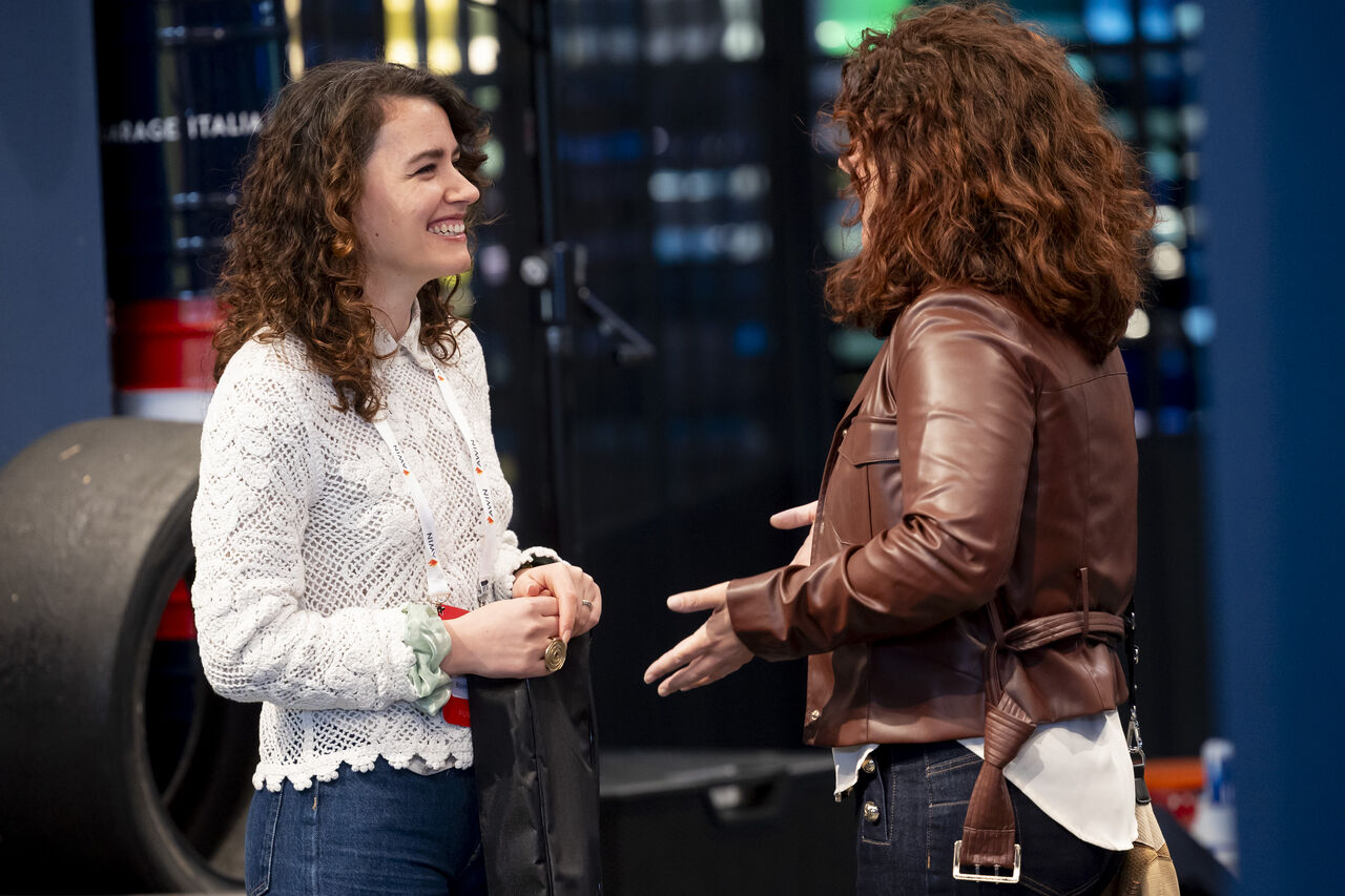 Two smiling young women talking at an affiliate event